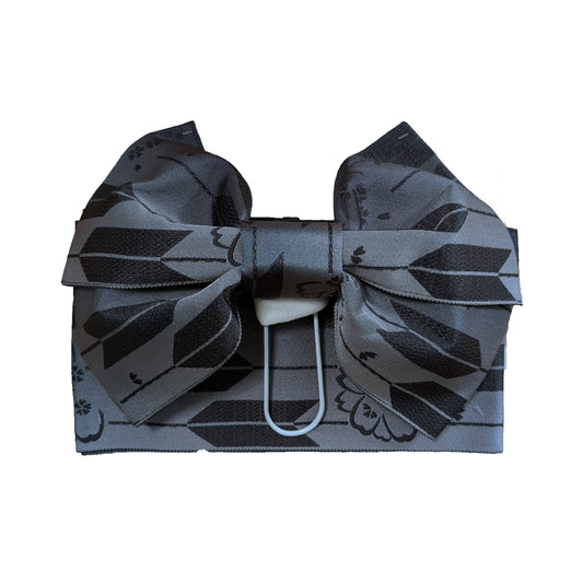 Gray Japanese obi bow with black geometric pattern on a white background