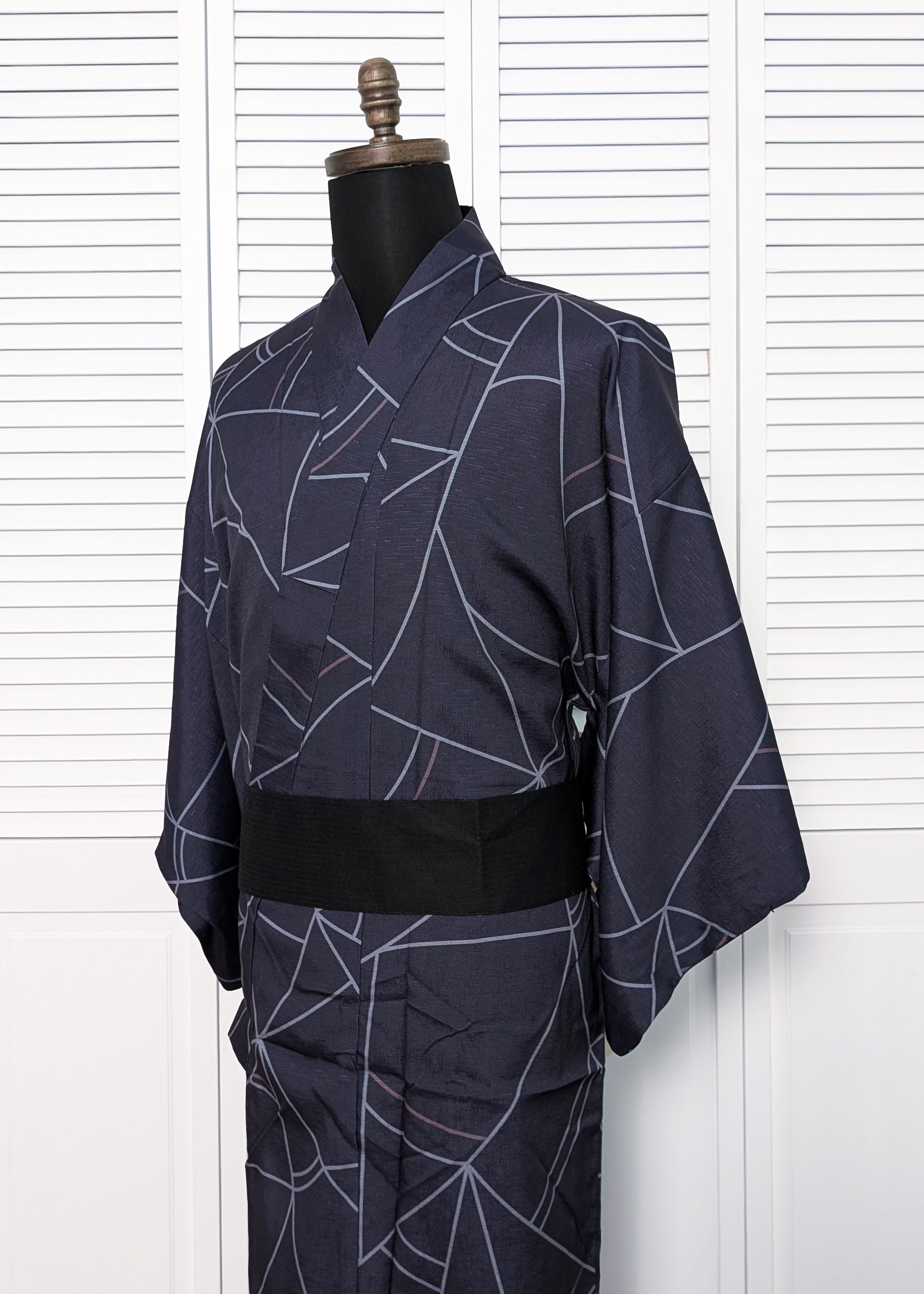 Navy blue kimono with white abstract patterns on a mannequin against a white background
