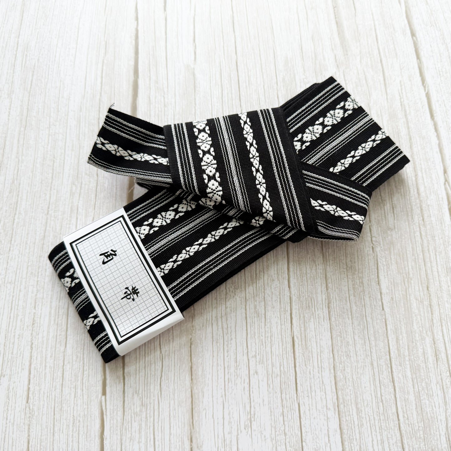 Black and white patterned fabric roll on a light wooden surface