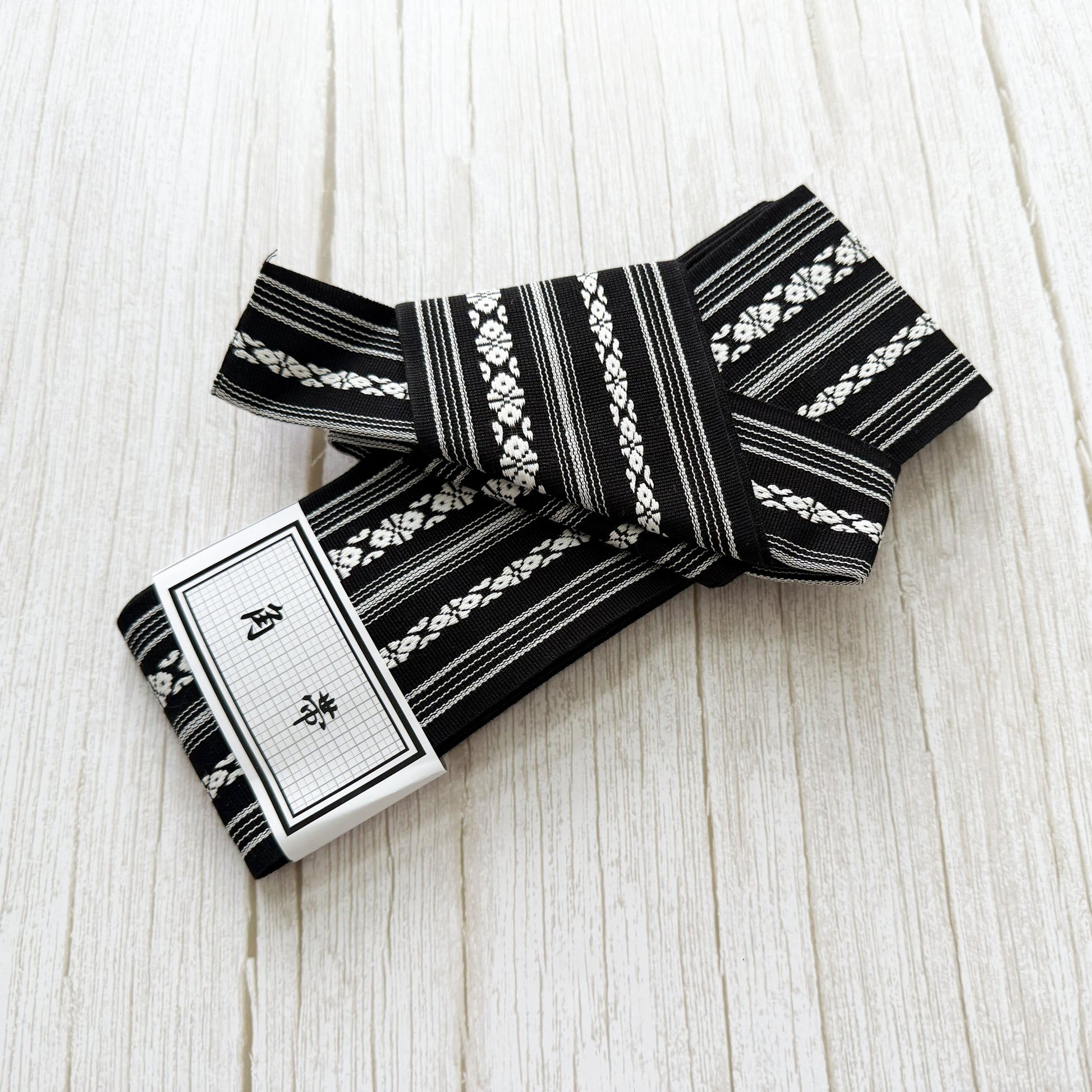 Black and white patterned fabric roll on a light wooden surface
