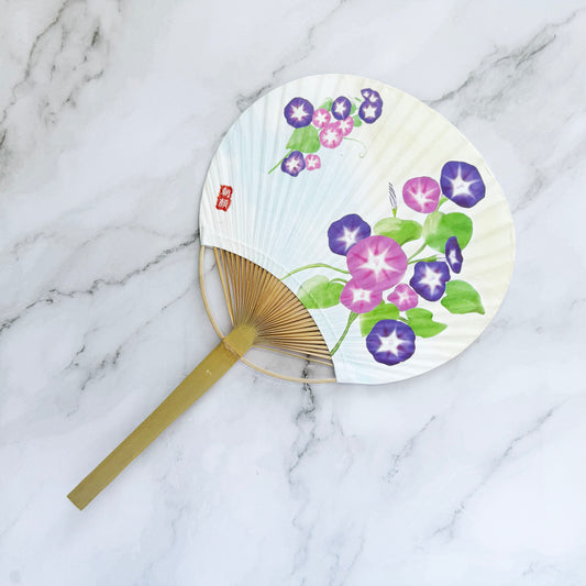 Handheld fan with floral design on a marble surface