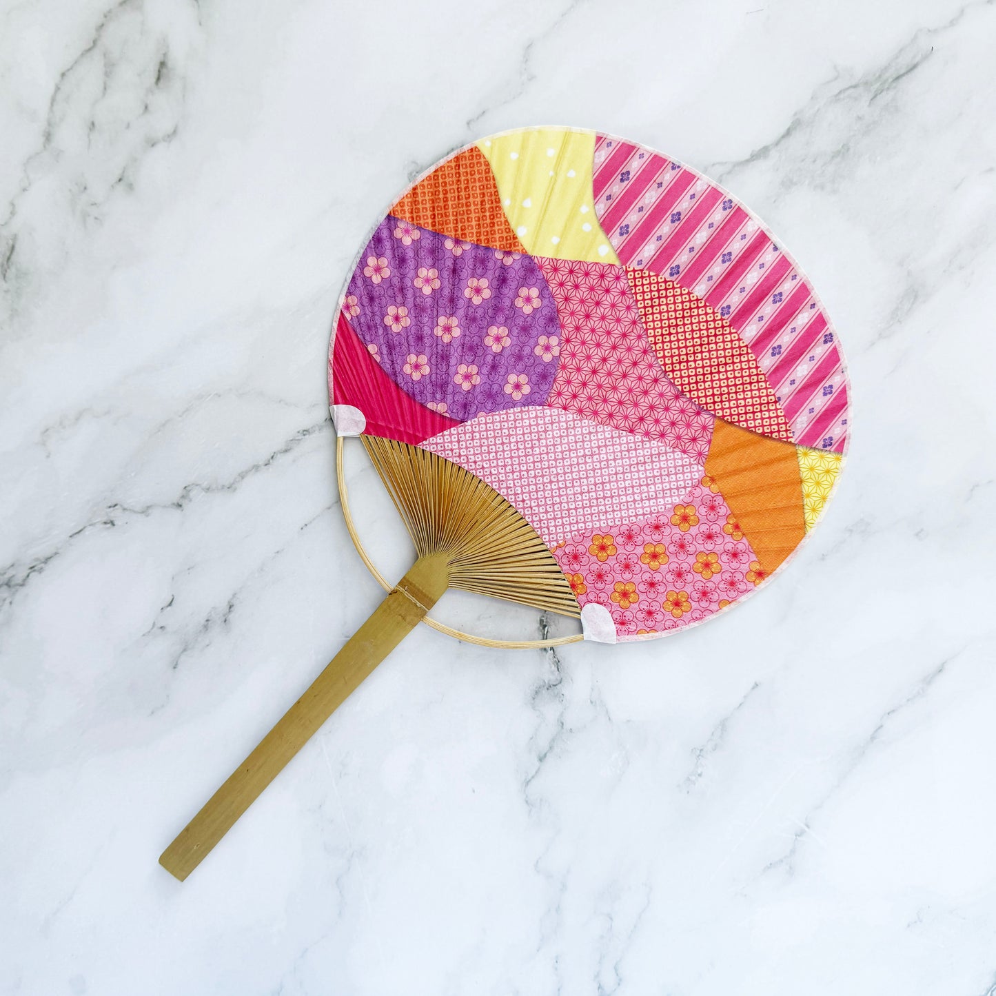 Colorful patchwork fan on a marble surface