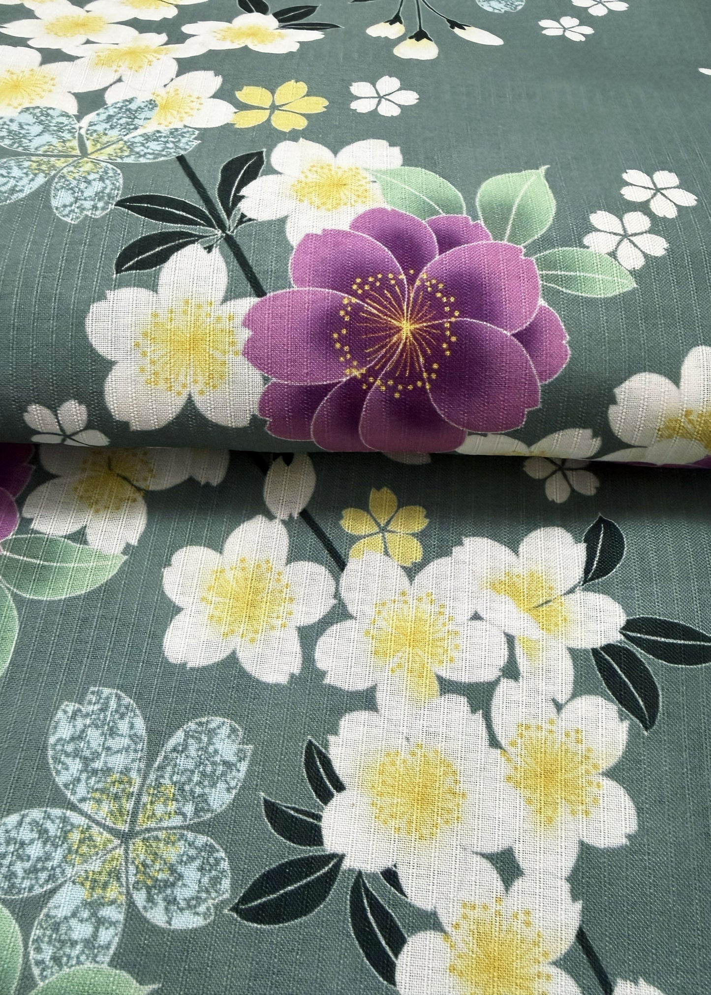 Floral fabric with purple and white flowers on a green background