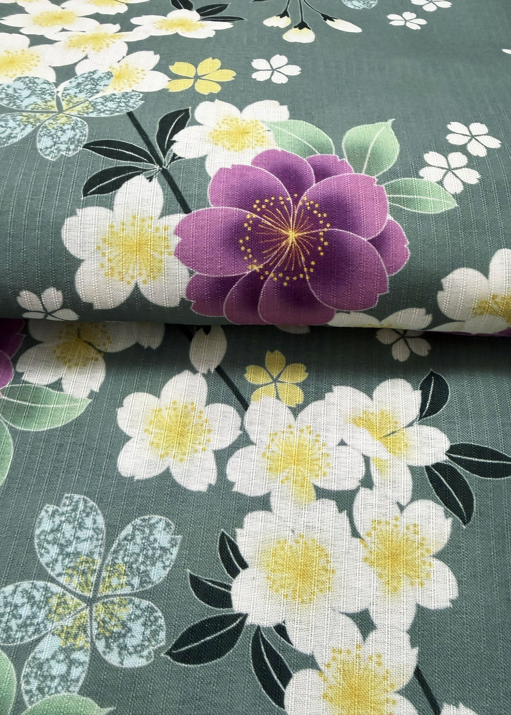 Floral fabric with purple and white flowers on a green background