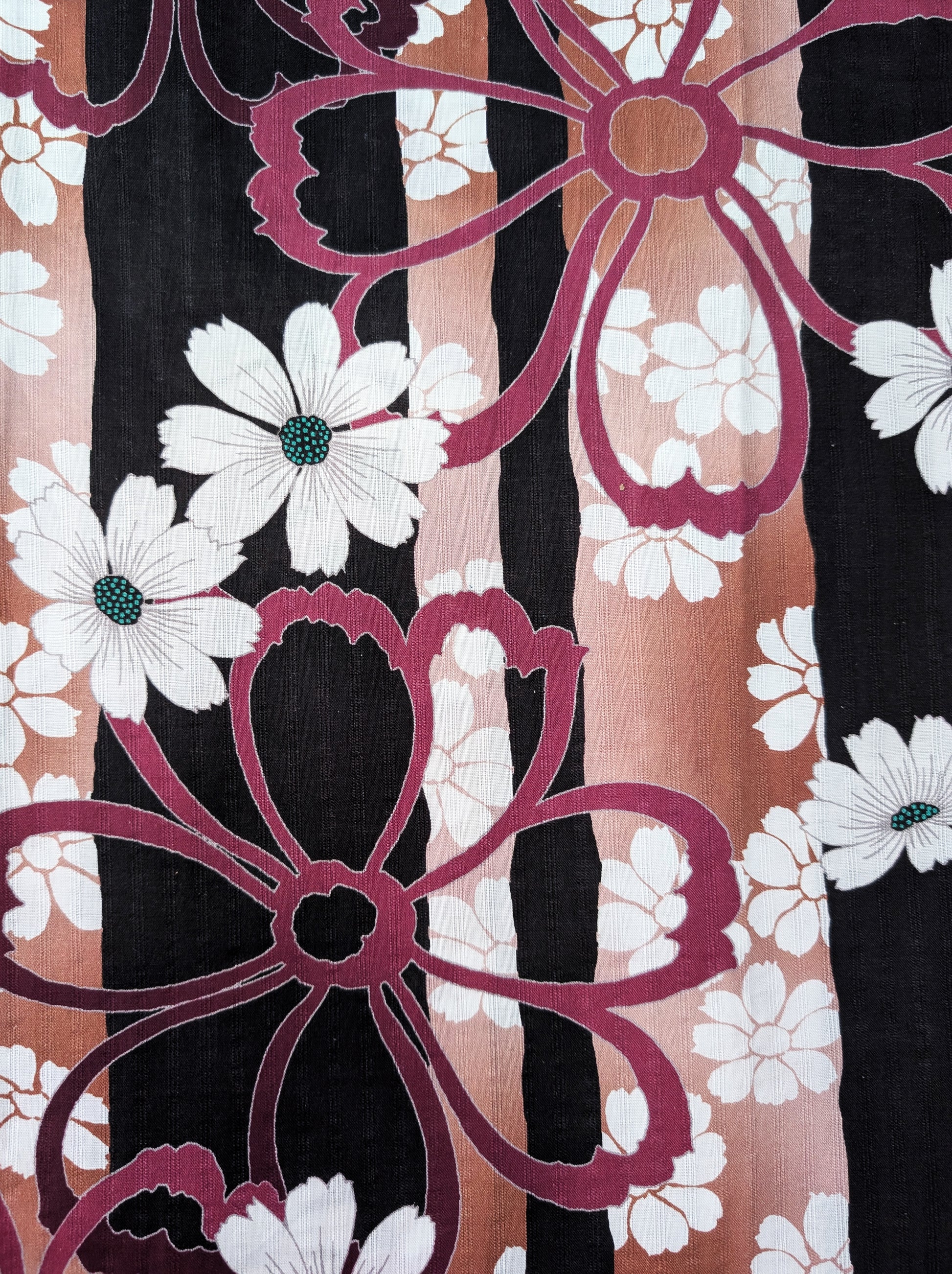 Close-up of a fabric with floral patterns in white, pink, and black.