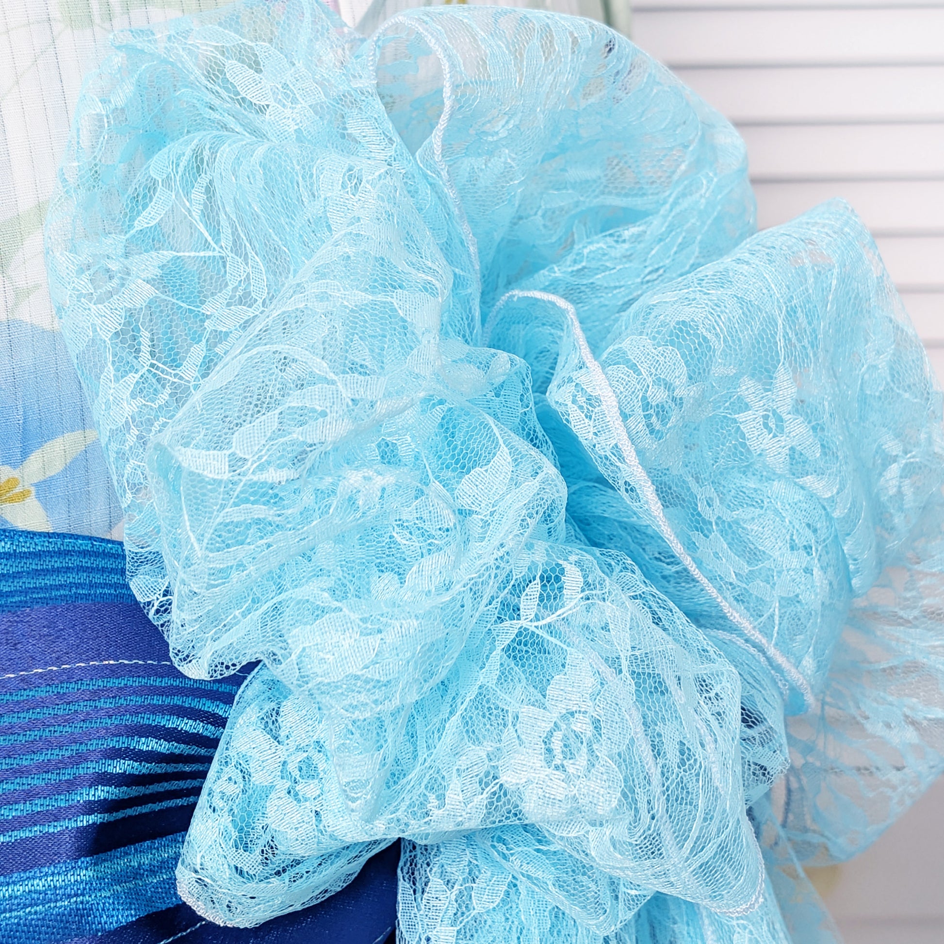 Close-up of a blue lace fabric with floral patterns.