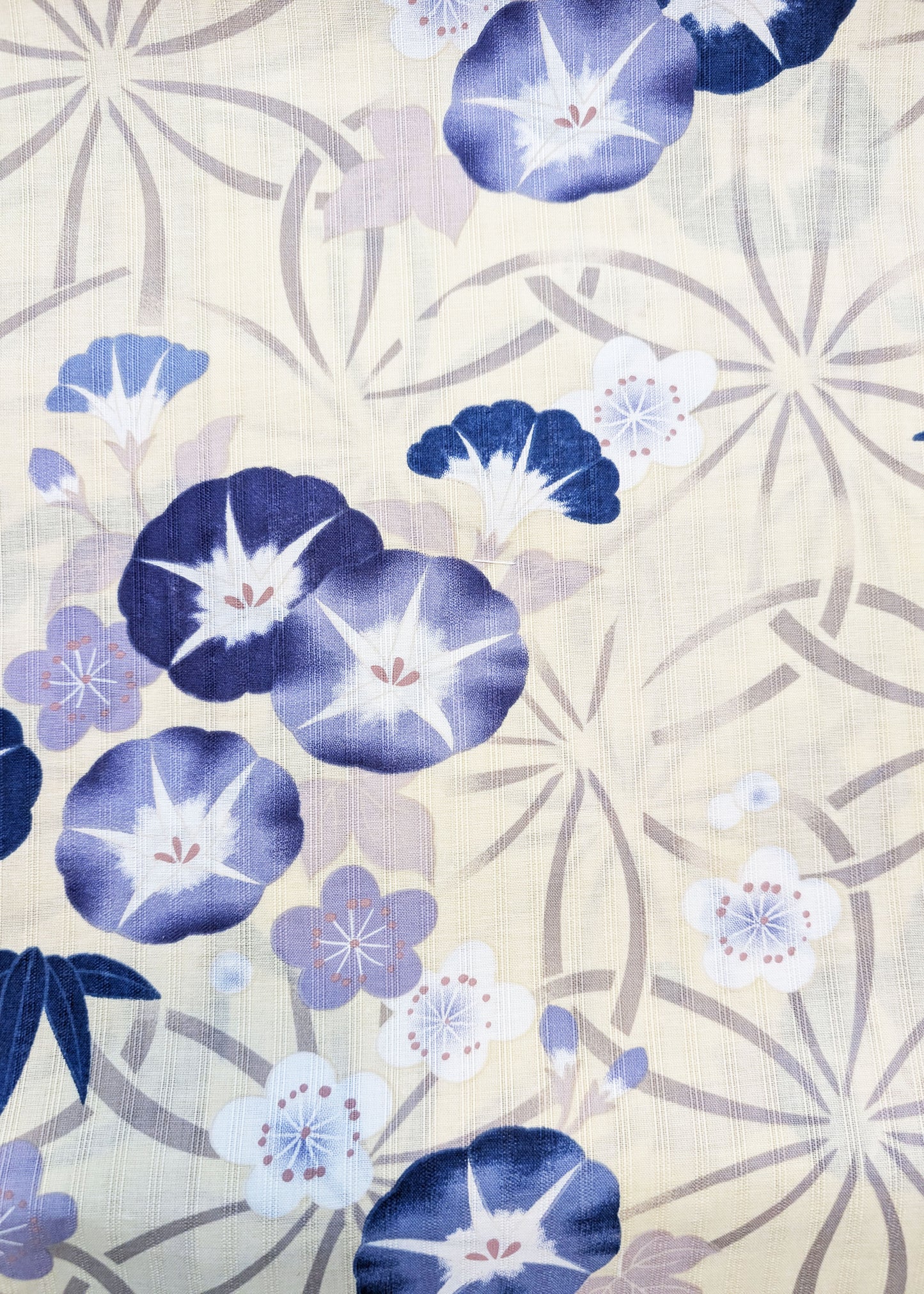 Patterned fabric with blue and purple flowers on a beige background