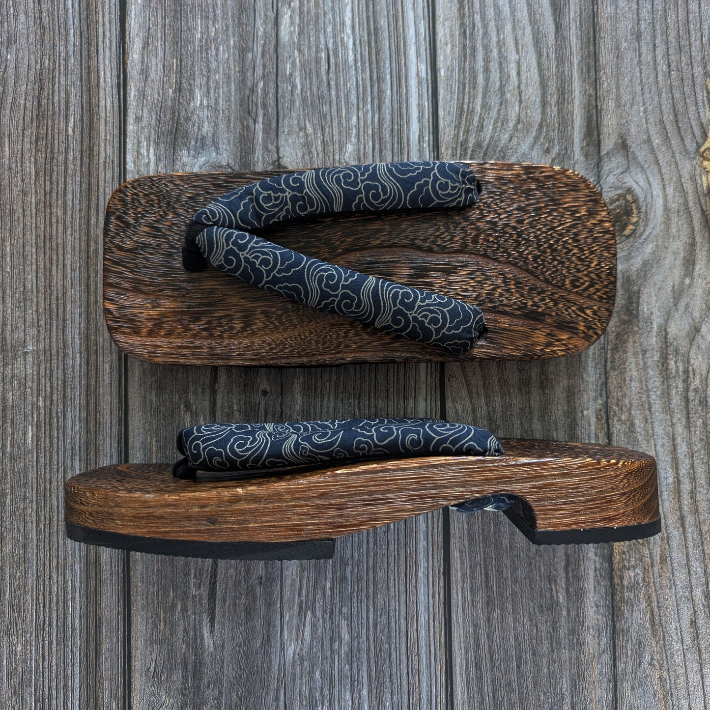 Wooden sandals with patterned straps on a wooden background